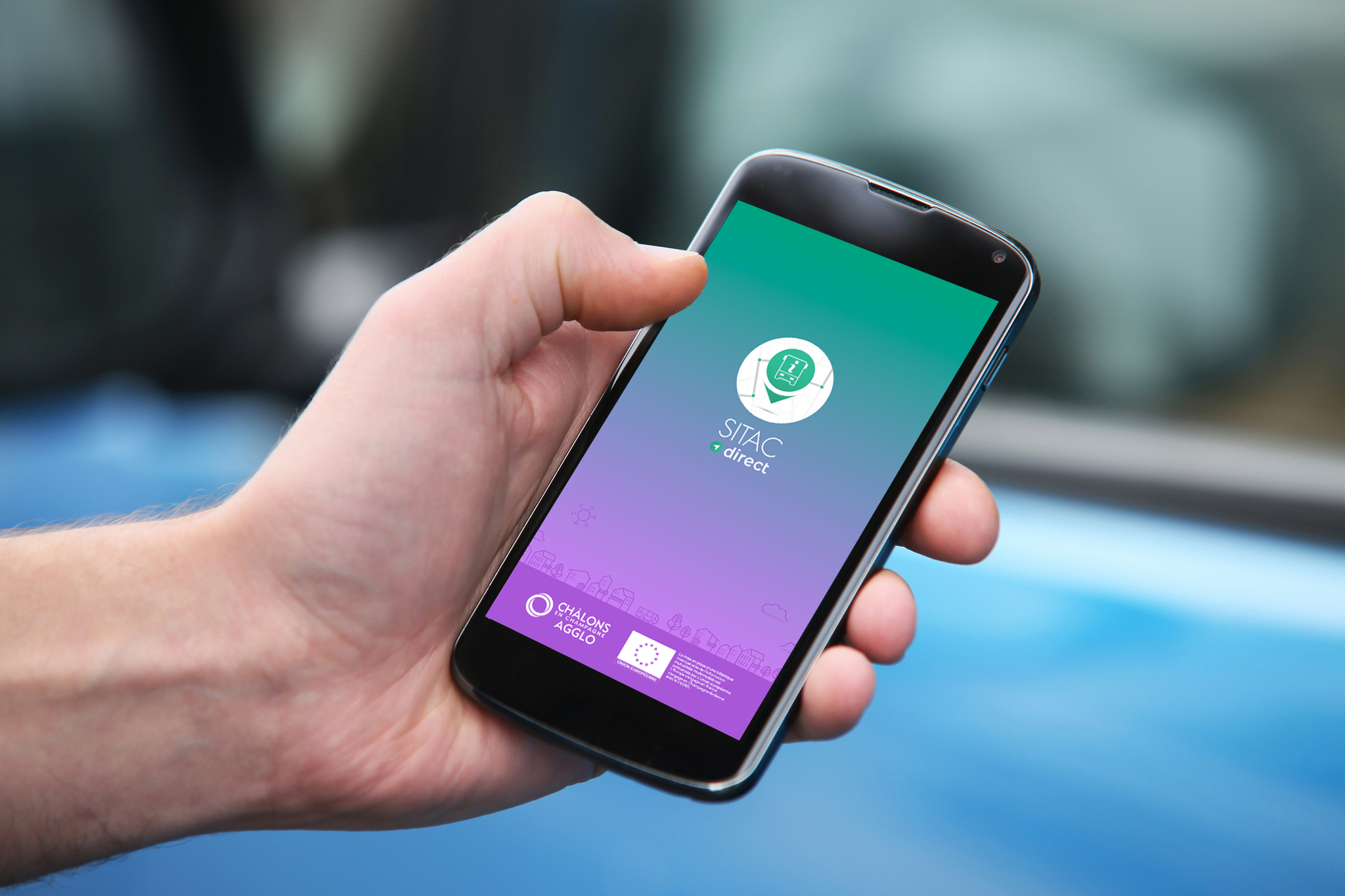Main tenant un smartphone, l'écran affiche la page d'accueil de l'application SITAC direct