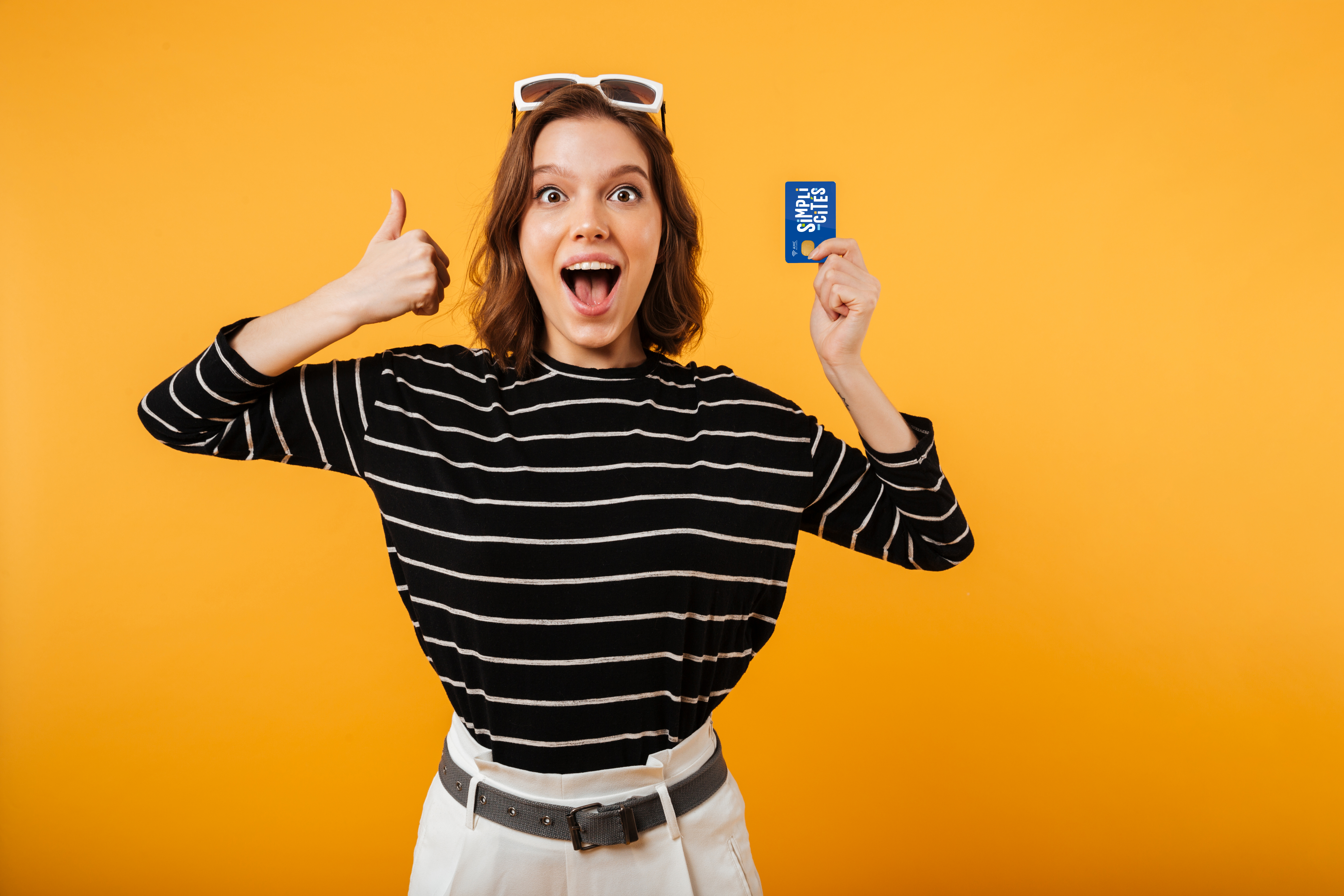 Jeune femme joyeuse avec en main une carte de transport Simplicités