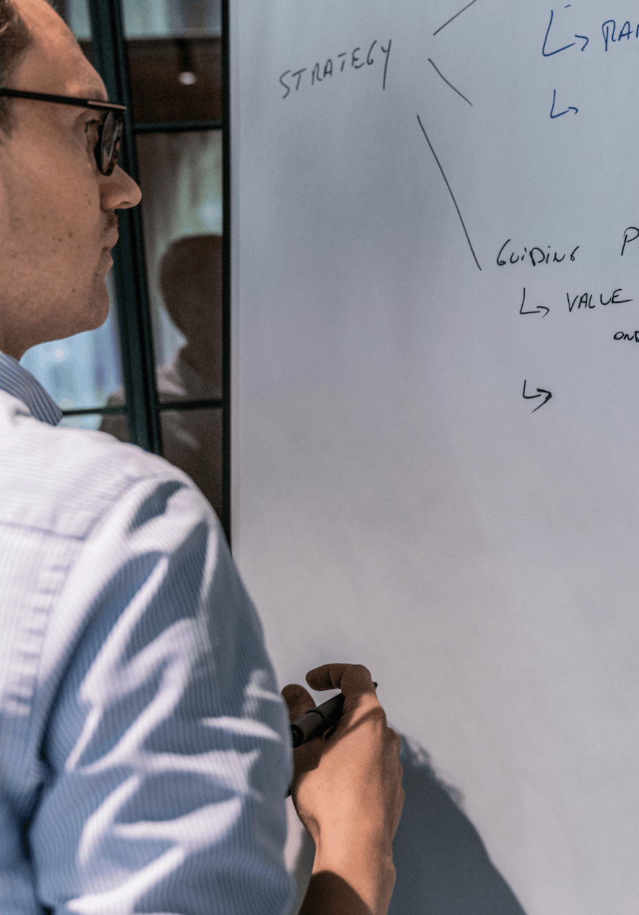 Man writing on whiteboard during a workshop session 