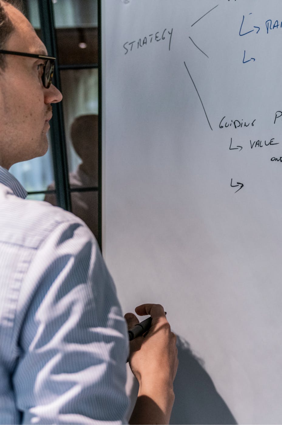 Man writing on whiteboard during a workshop session 