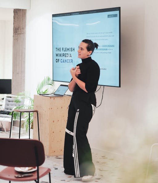 Photo of a woman standing in front of a big screen presenting during the food for thought at Craftzing
