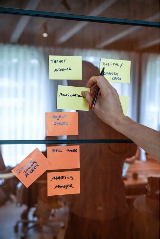 Photo showing a hand sticking post it notes to a wall