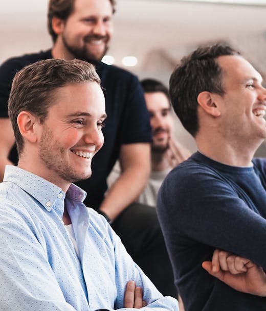 crowd of men shown sideways smiling to the right side