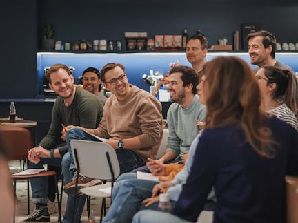 Group picture of Craftzing colleagues smiling and listening to a presentation