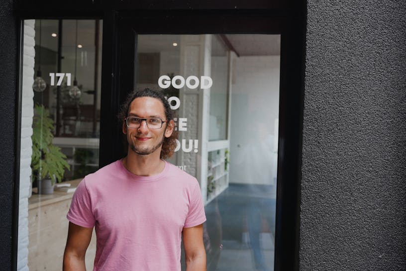 Craftzing colleague Rémi standing in front of the office door in Ghent