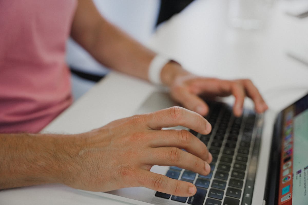 Hands typing on a laptop