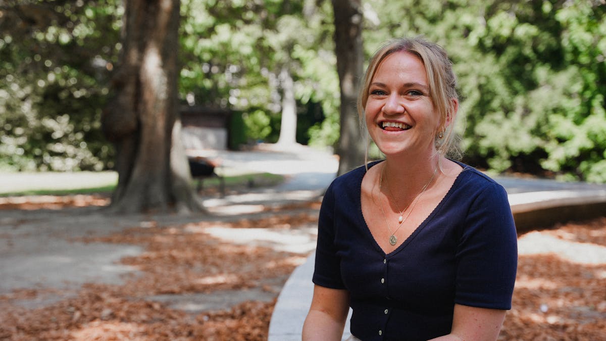 Woman laughing into the camera seated in a park