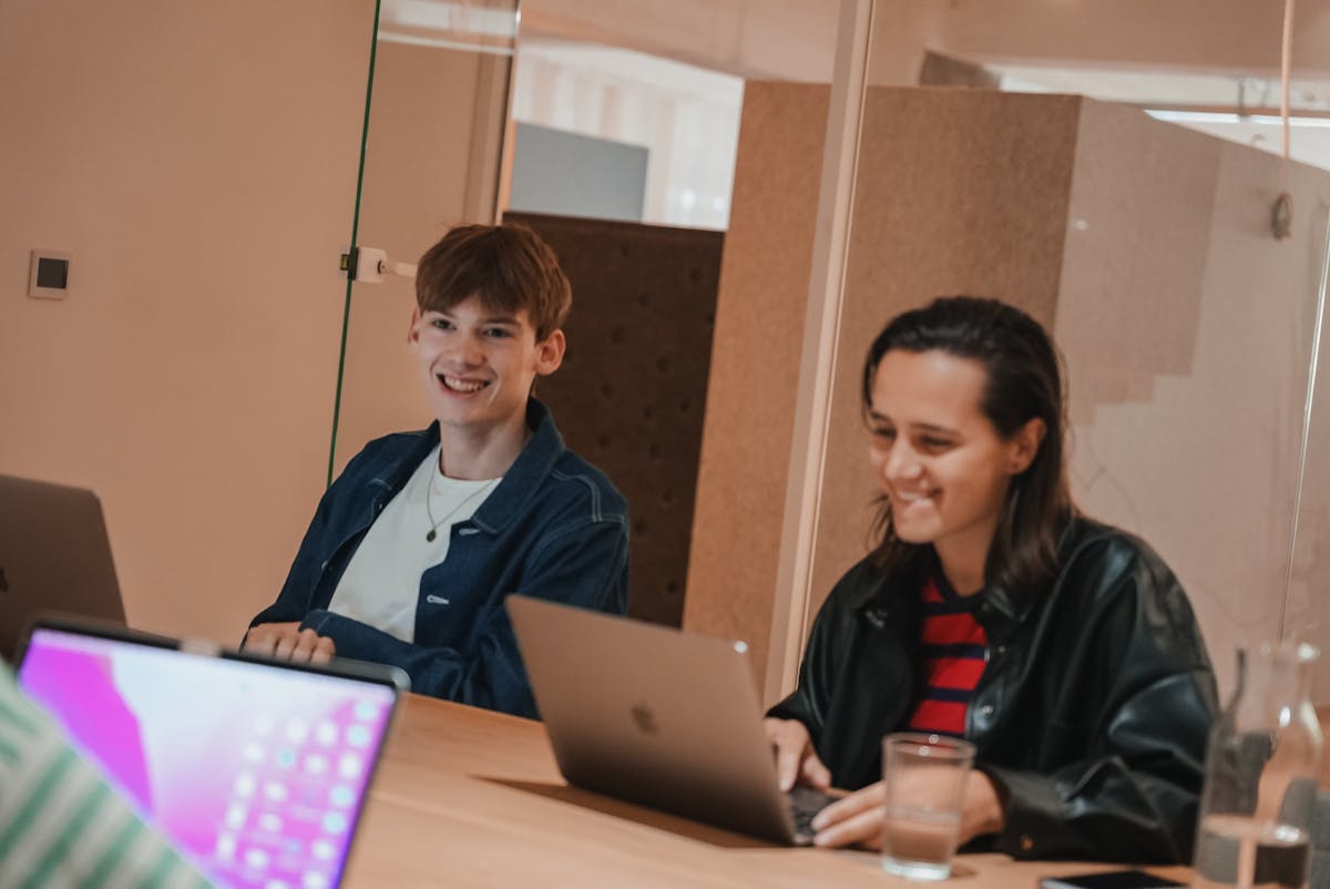 Previous intern Tommy and Craftzing colleague Elise sitting in a meeting room and laughing