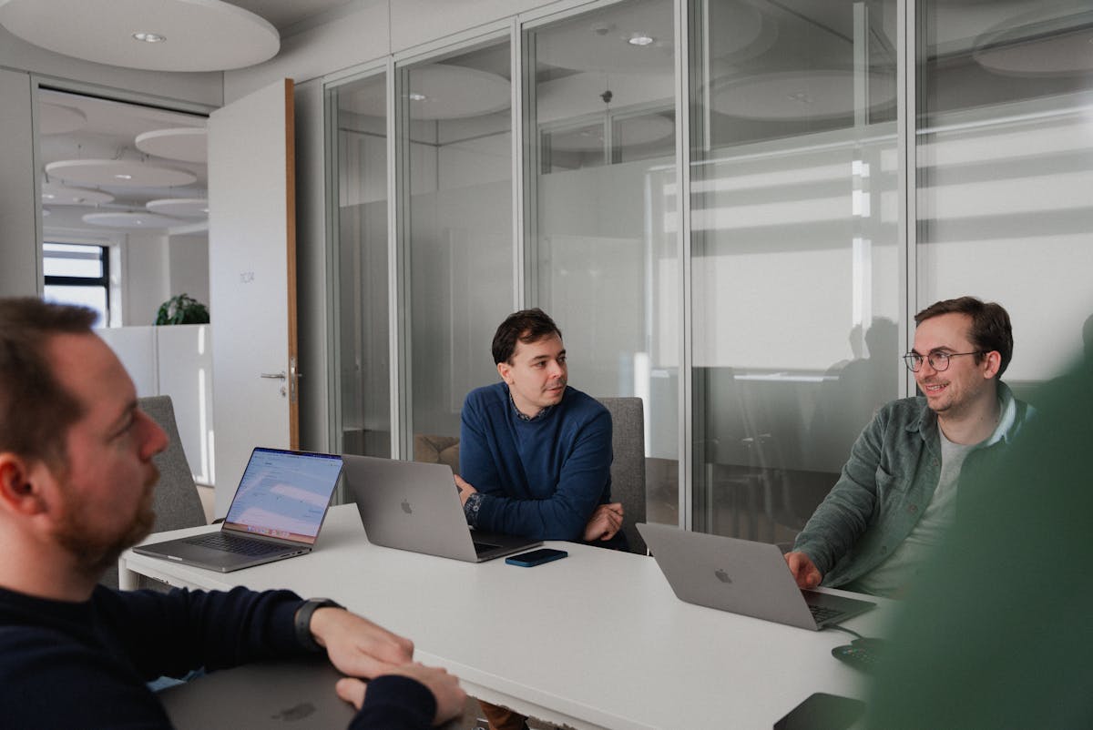 Three people sitting around a table in a meeting room