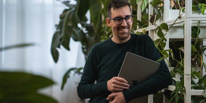 UX and concept designer Martijn leunend tegen een rek vol planten