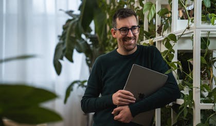 UX and concept designer Martijn leunend tegen een rek vol planten