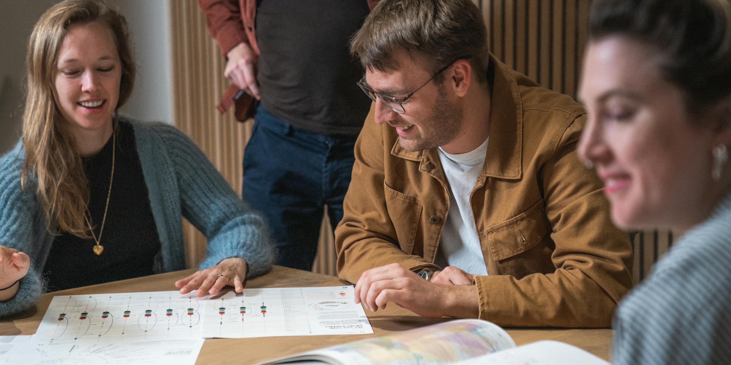 Craftzing's data team in a meeting room looking at a graphic