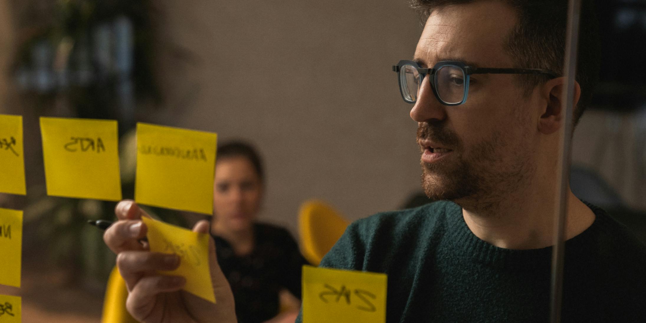 A Craftzing colleague hanging a written post-it on a window