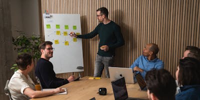 A man explaining a diagram to his colleagues in a meeting room