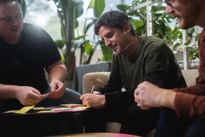 Photo of a man writing on a post-it