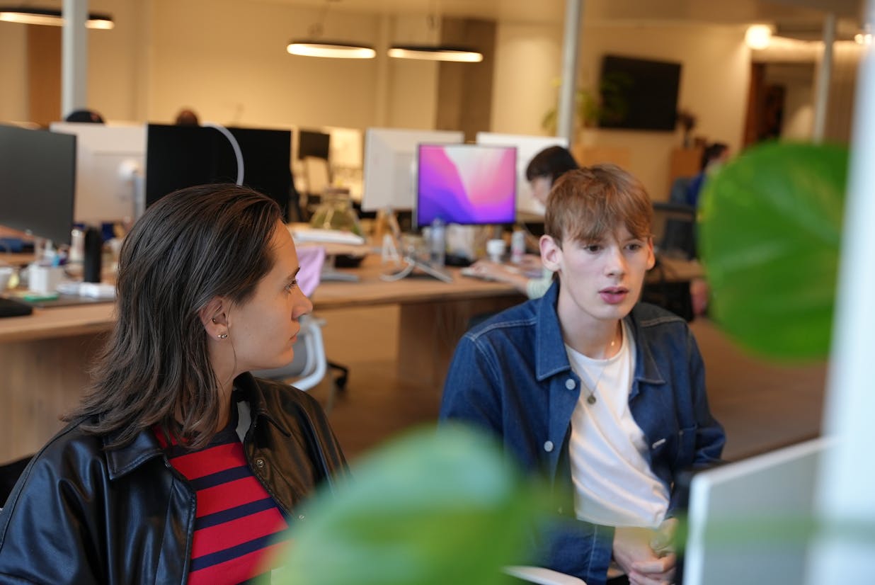 Elise and our previous intern Tommy in the office looking at a screen