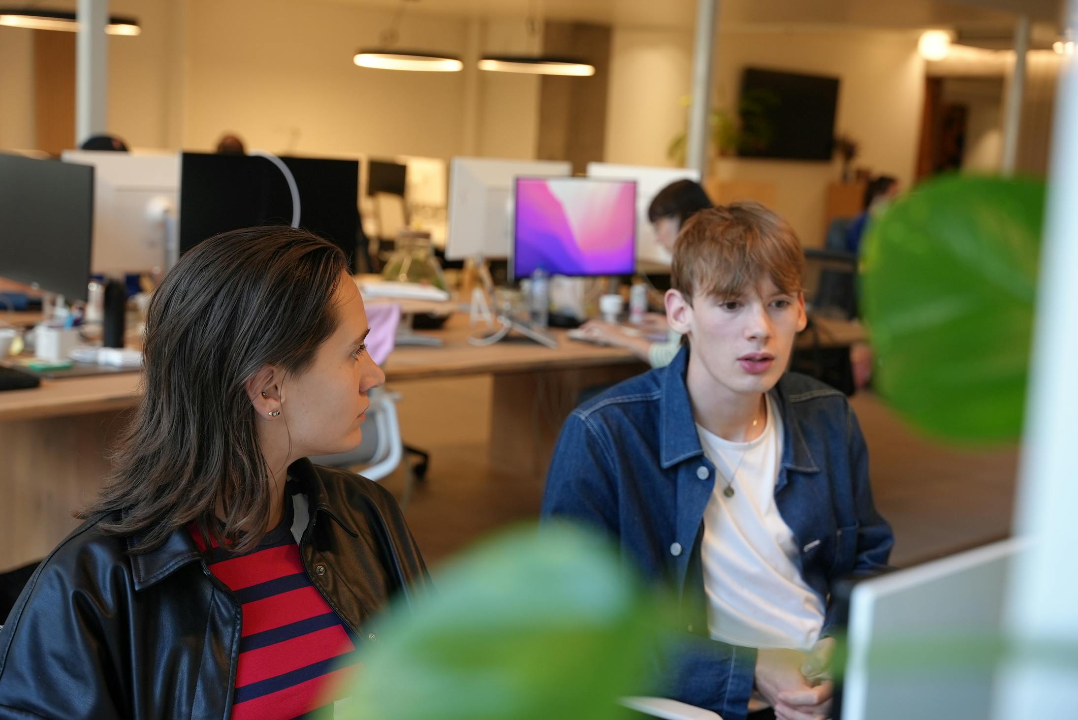 Elise and our previous intern Tommy in the office looking at a screen