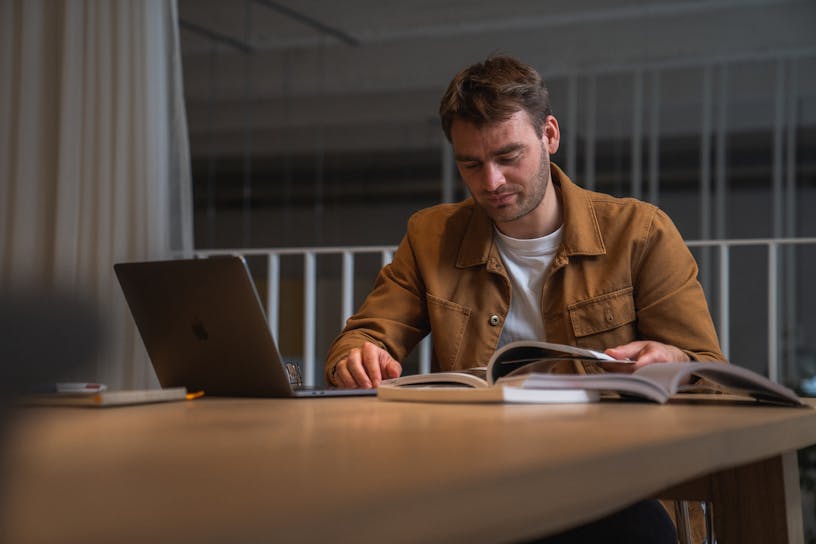 Our data strategist Maarten Vanhoof sitting at a desk reading a book.