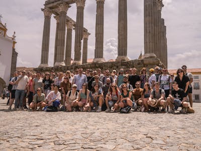 About 60 Craftzing colleagues posing for a picture in a front of an old Roman statue in the city of Evora in Portugal