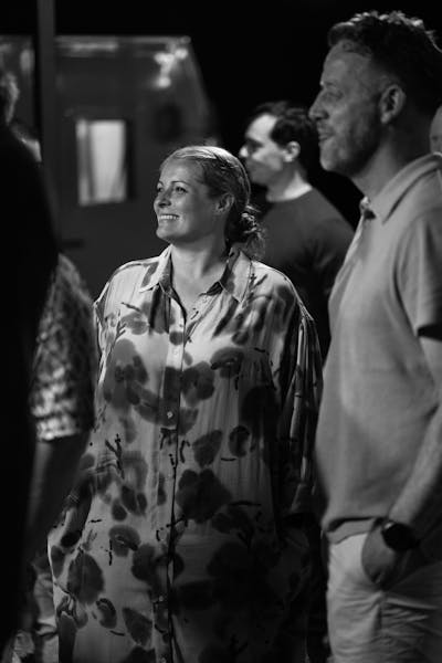 Black and white portrait of a woman wearing a dress, smiling.
