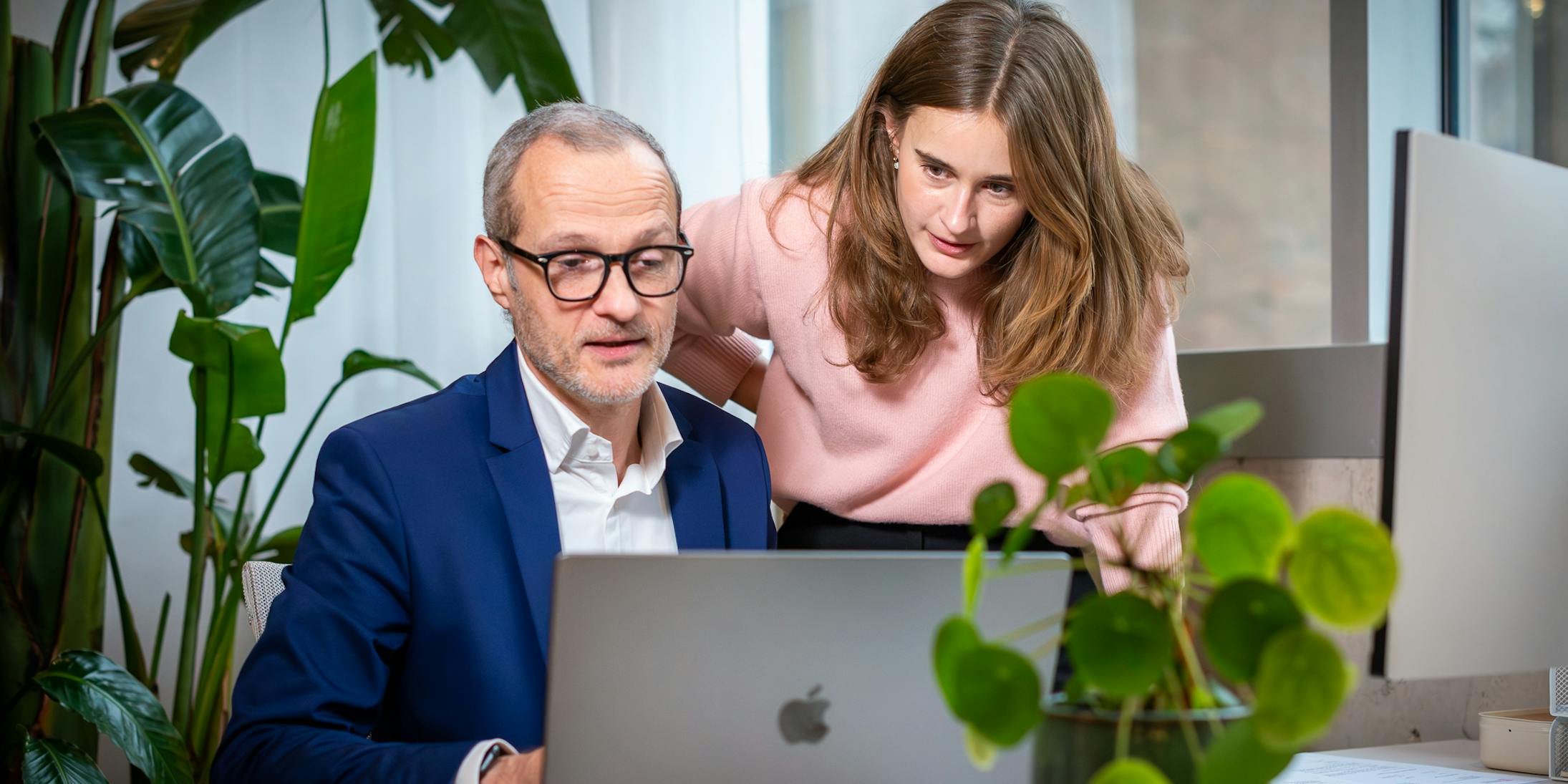 Two Craftzing colleagues in the office looking at a laptop screen