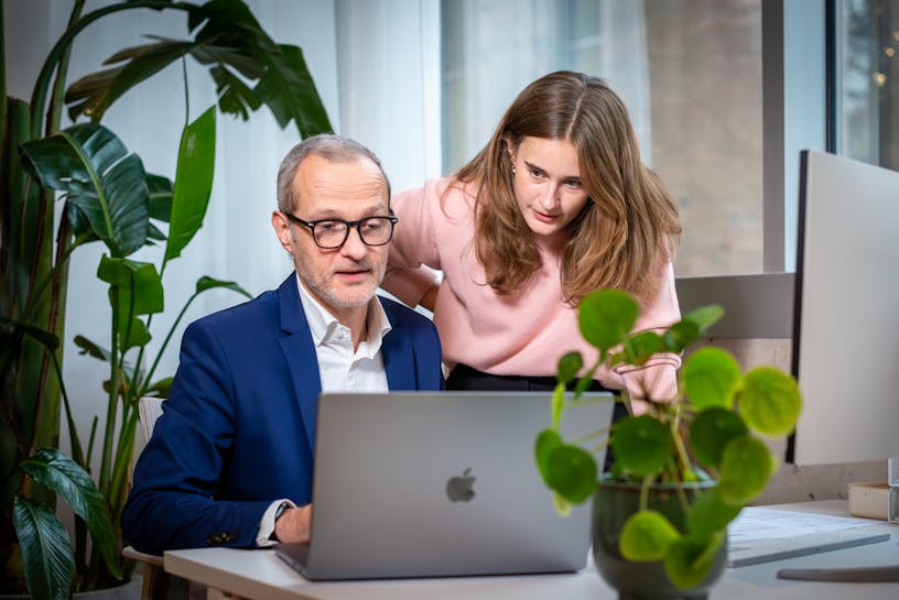 Two Craftzing colleagues in the office looking at a laptop screen