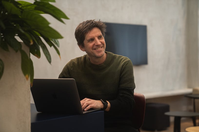 Gijs at the office smiling from behind his laptop