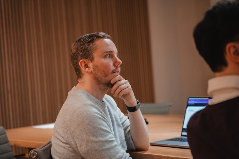 Craftzing's creative director Ives De Blieck sitting in a meeting room, listening.