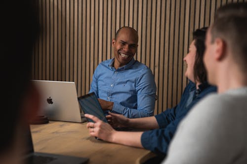 Craftzing colleagues sitting around a table looking at each other and laughing
