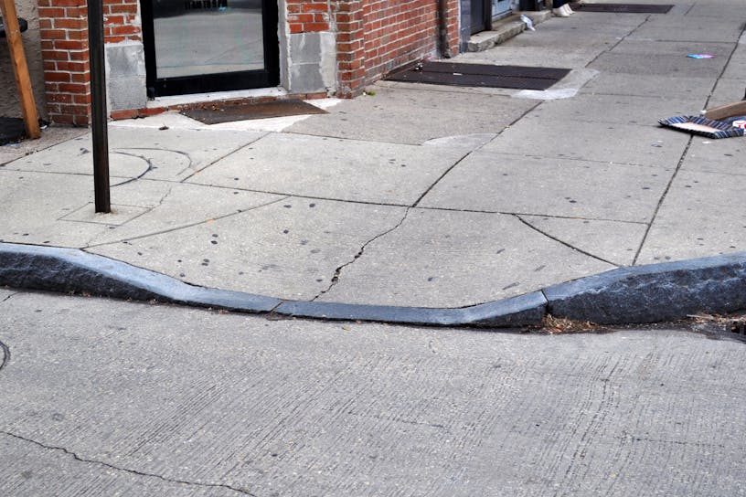 A ramp in the sidewalk (curb cut) of a street.