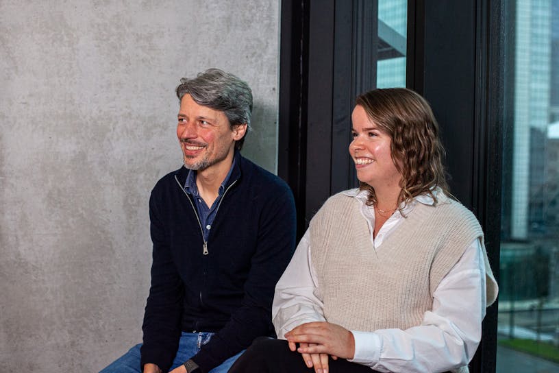 Bert Taelman and Eline De Block sitting next to each other smile towards a person left on the picture but who's not visible.