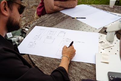 A person is writing something on a large piece of paper.