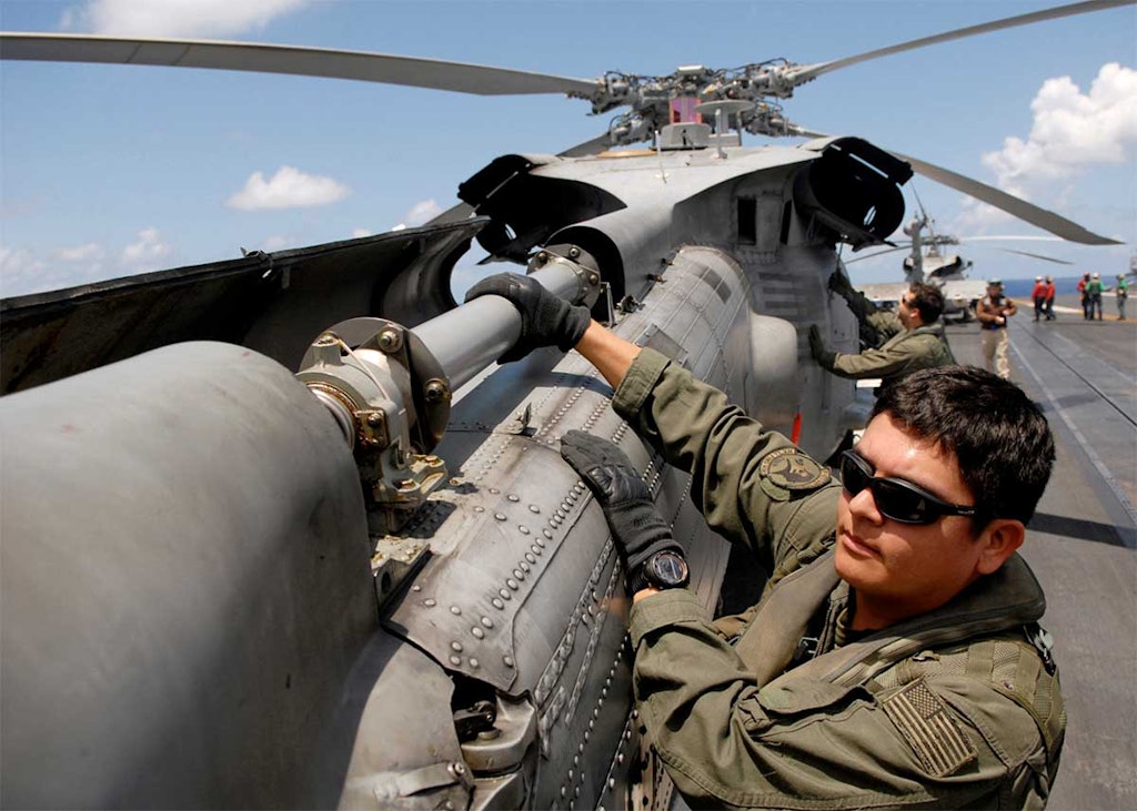 Petty Officer 2nd Class James R. Evans inspects the drive shaft of a helicopter rear rotor U.S. Navy