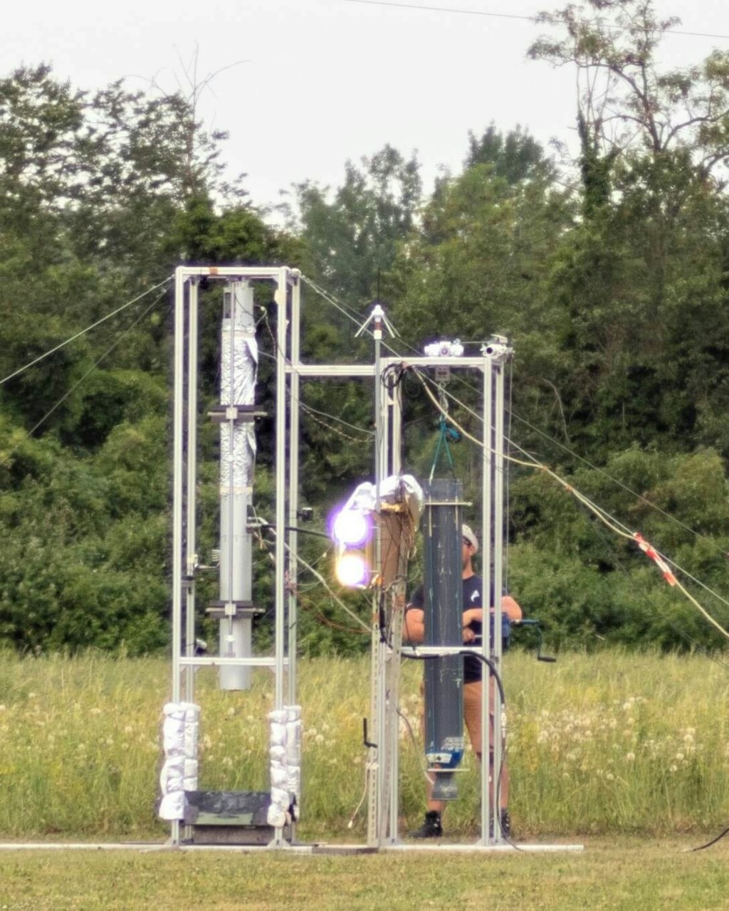 Figure 5. Test rig during a static fire test. Test stand with Chimæra on the left and commercial N2O tank stand on the right.