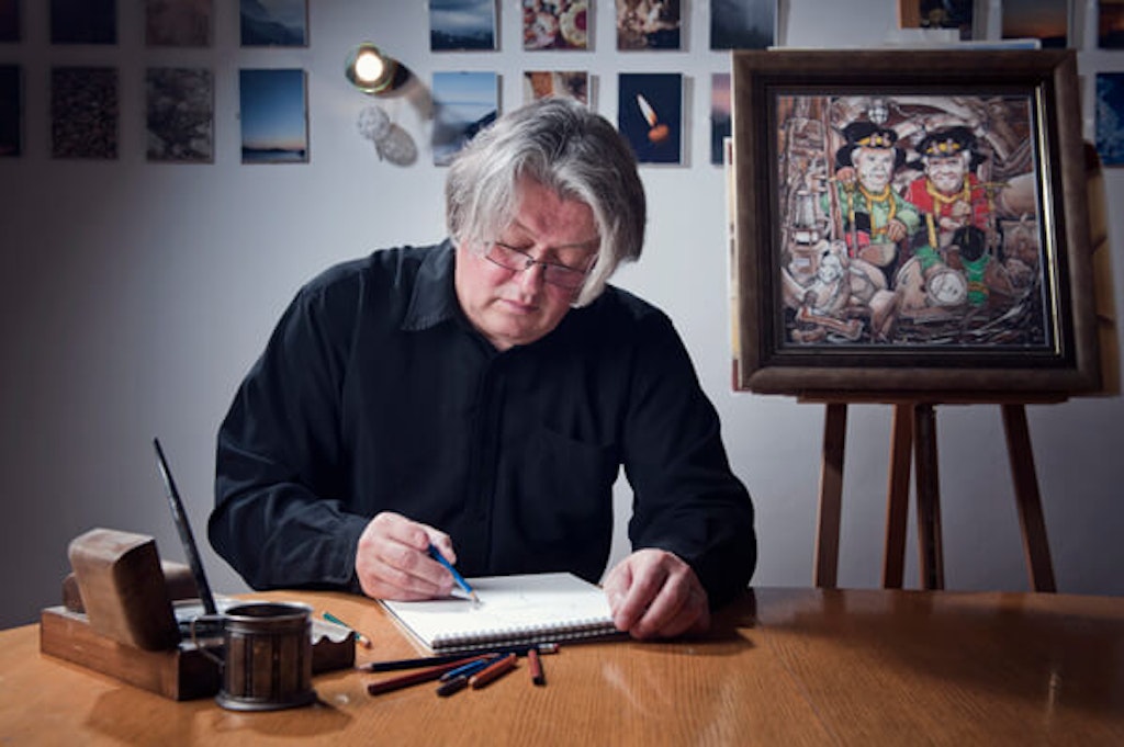 The painter Jože Ovnik, a founding member of the Perkmandeljc Mining Heritage Preservation Society, with one of his paintings of mining gnomes.