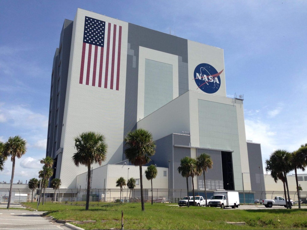 Figura 18. Completato nel 1966, il Vehicle Assembly Building (VAB) presso il Kennedy Space Center è stato costruito appositamente per l'assemblaggio e l'integrazione delle missioni spaziali Apollo del Saturn V. Le porte principali hanno un'altezza di 456 piedi (139 metri) ed impiegano 45 minuti per aprirsi o chiudersi completamente.  Foto del 2013 di Grant Maloy Smith.