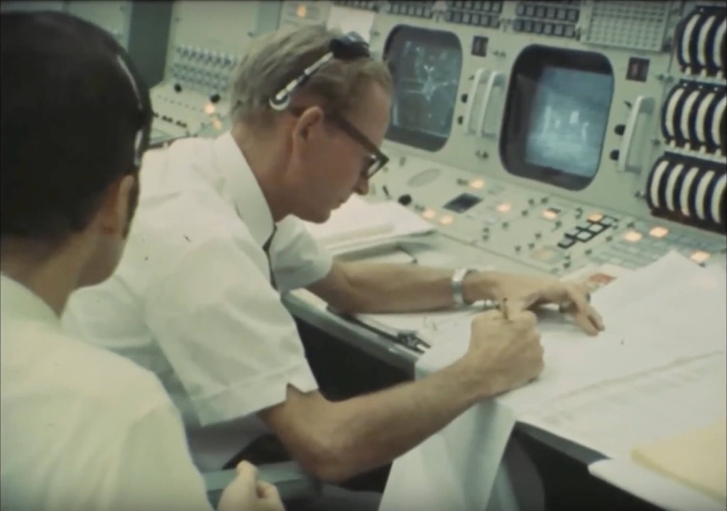 Figura 14. Il responsabile del volo della NASA per Apollo 11, D.J. MacDonald, aggiunge commenti ad una registrazione su strisce. Immagine tratta da un video della NASA del 1969.