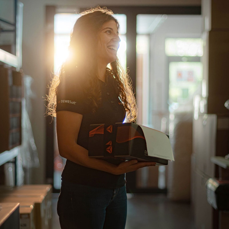 Logistics and purchasing Dewesoft employee holding a Dewesoft shipping package
