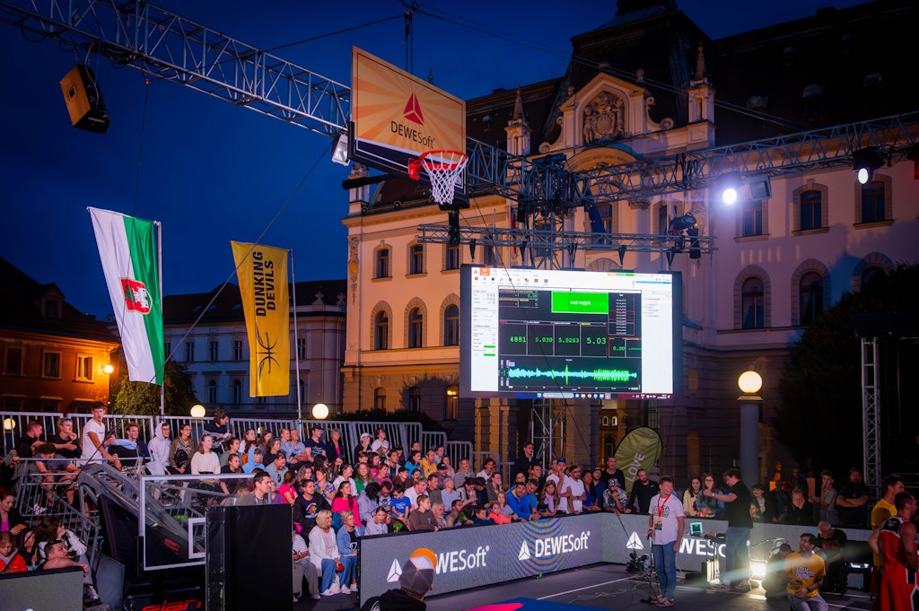 Figure 6. The action is on! The event arena with the hoop rigged for measurement and a big screen displaying the results.