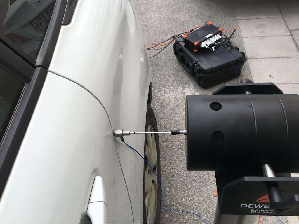 A car door is subjected to modal testing using a Dewesoft DAQ system and shaker