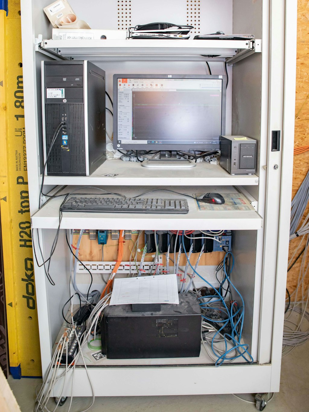 The Dewe-43 data acquisition system is in an appliance cabinet next to a computer
