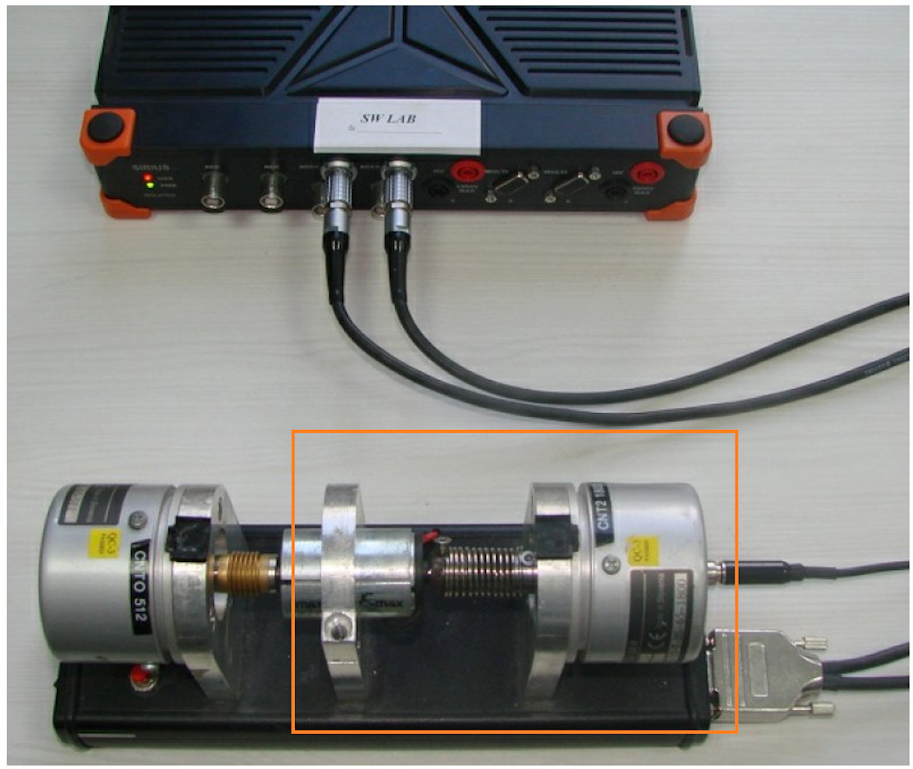 For our test, we take an electric motor (in the middle) and two encoders. The encoder on the left is connected with coupling and the encoder on the right with a spring to the motor, to create high vibrations.  Because we are currently only interested in rotational vibration, we will only use the encoder on the right side, connected with the spring. The encoder is connected to the Dewesoft instrument on a Counter input.