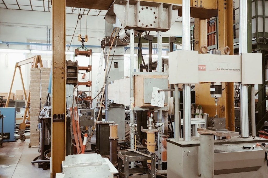 Figura 1. Il laboratorio con i macchinari per le prove di stress sui materiali e il modello in scala della struttura.