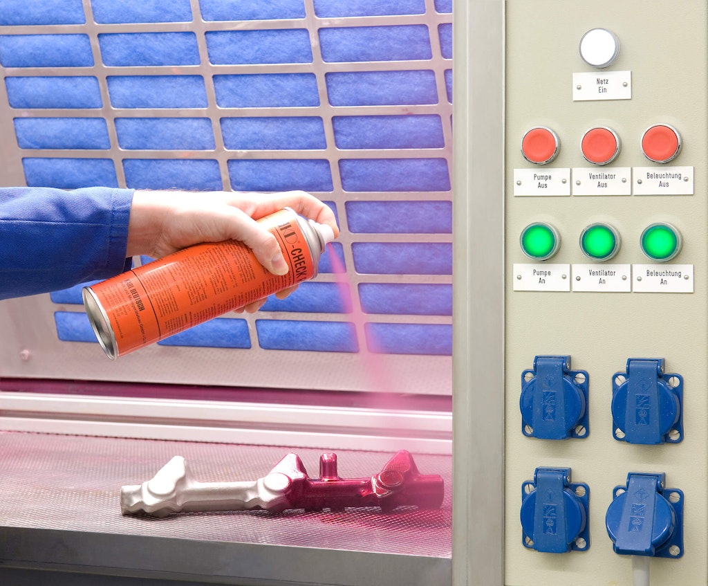 A dye penetrant is sprayed onto a test article. Karl Deutsch Prüf- und Messgerätebau GmbH + Co KG, CC BY 3.0 DE via Wikimedia Commons