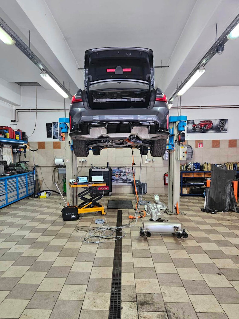 The BMW on the lift so we could run the high-voltage lines to the SIRIUS XHS-PWR in the trunk The BMW on the lift so we could run the high-voltage lines to the SIRIUS XHS-PWR in the trunk