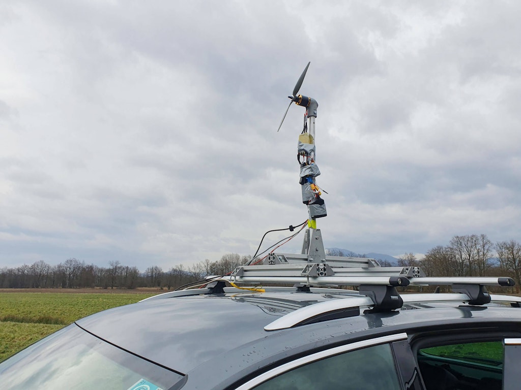 Figure 4. The mobile test rig with strain gauges, a motor, and a battery on the roof of a car.