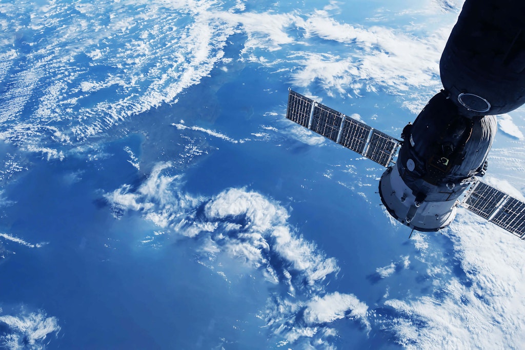 A communicates satellite orbiting the earth – image by NASA and Shutterstock.