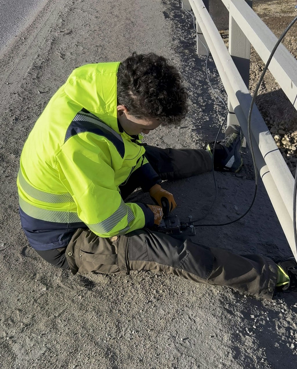 Figure 10. An engineer connecting sensor cables to a Dewesoft data acquisition unit (DAQ), part of the system that collects and transmits the monitoring data from the bridge abutment.