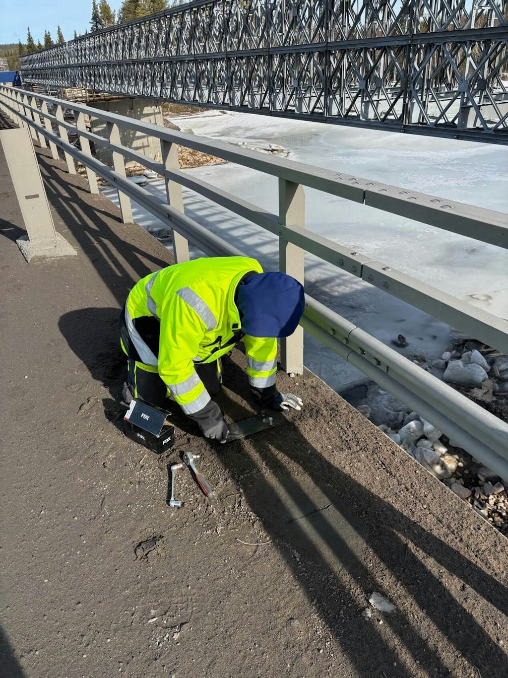 Figure 7. Installation detail showing a mounting plate being carefully screwed onto the bridge deck to provide a stable base for sensors.