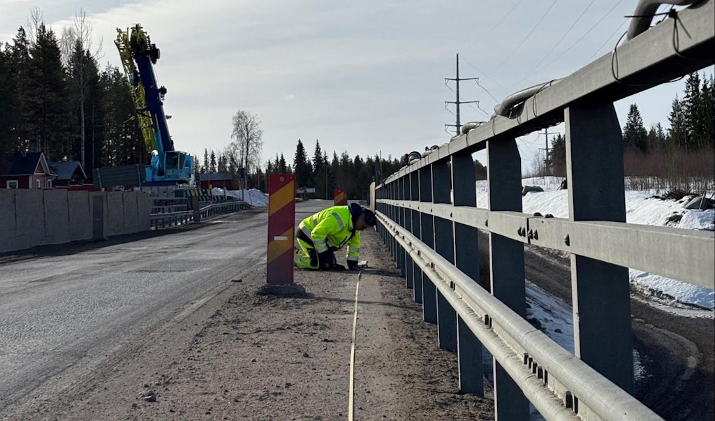 Figure 8. An engineer is installing an accelerometer on a mounting plate on the bridge deck.